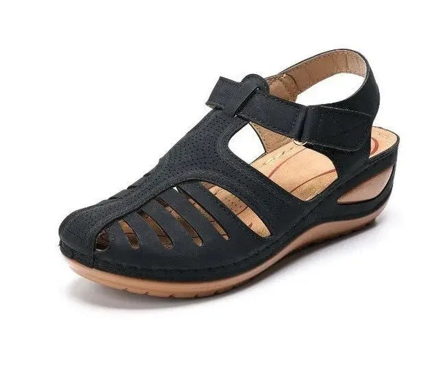 Black closed-toe wedge sandal with cut-out sides and touch-strap fastening