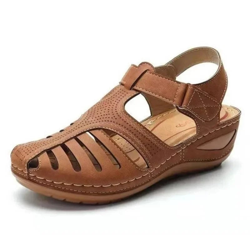 Tan leather-look wedge sandal featuring cut-out detailing and stitched trim