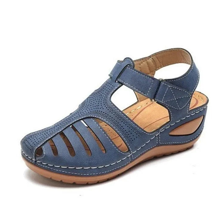 Navy blue closed-toe wedge sandal with cut-out panels and hook-and-loop strap