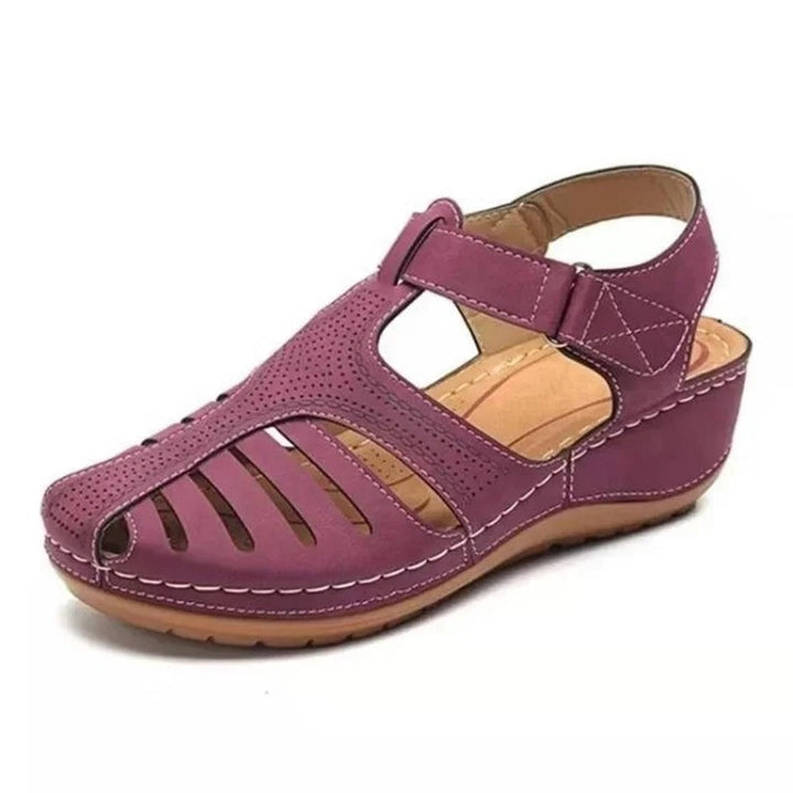 Purple wedge sandal with cage-style cut-outs and adjustable ankle strap
