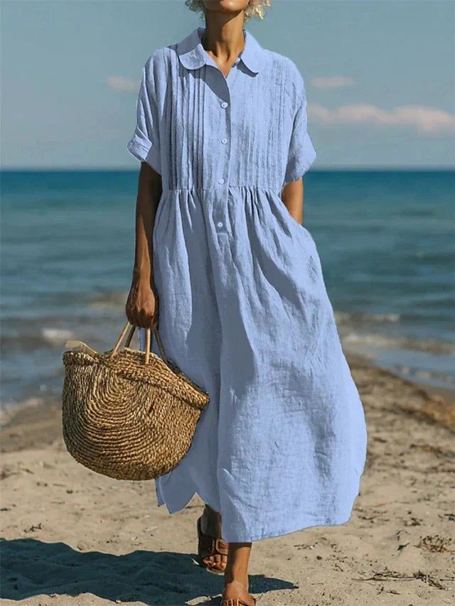 Pale blue collared button dress with pleated bodice by the seaside