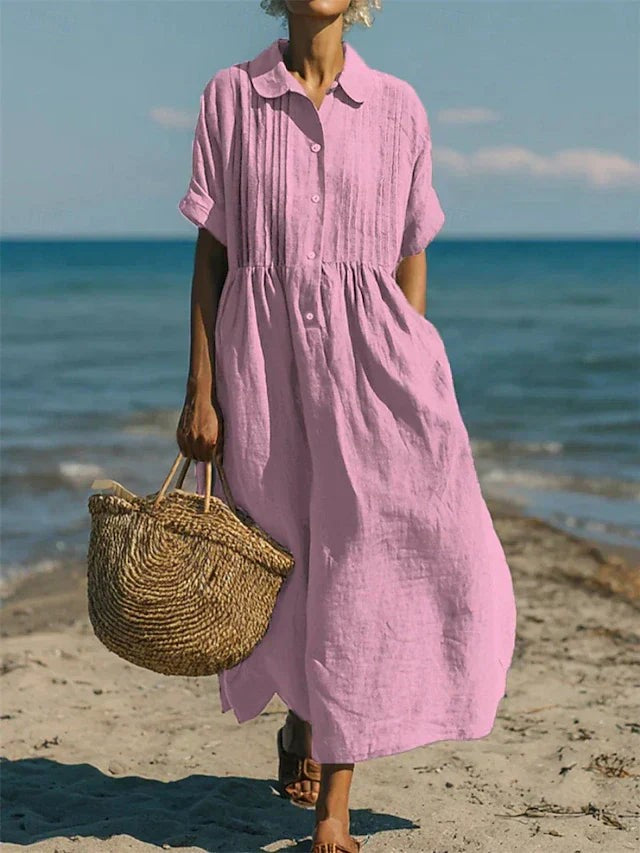 Dusty pink collared linen dress with pin-tucked bodice on sandy shore