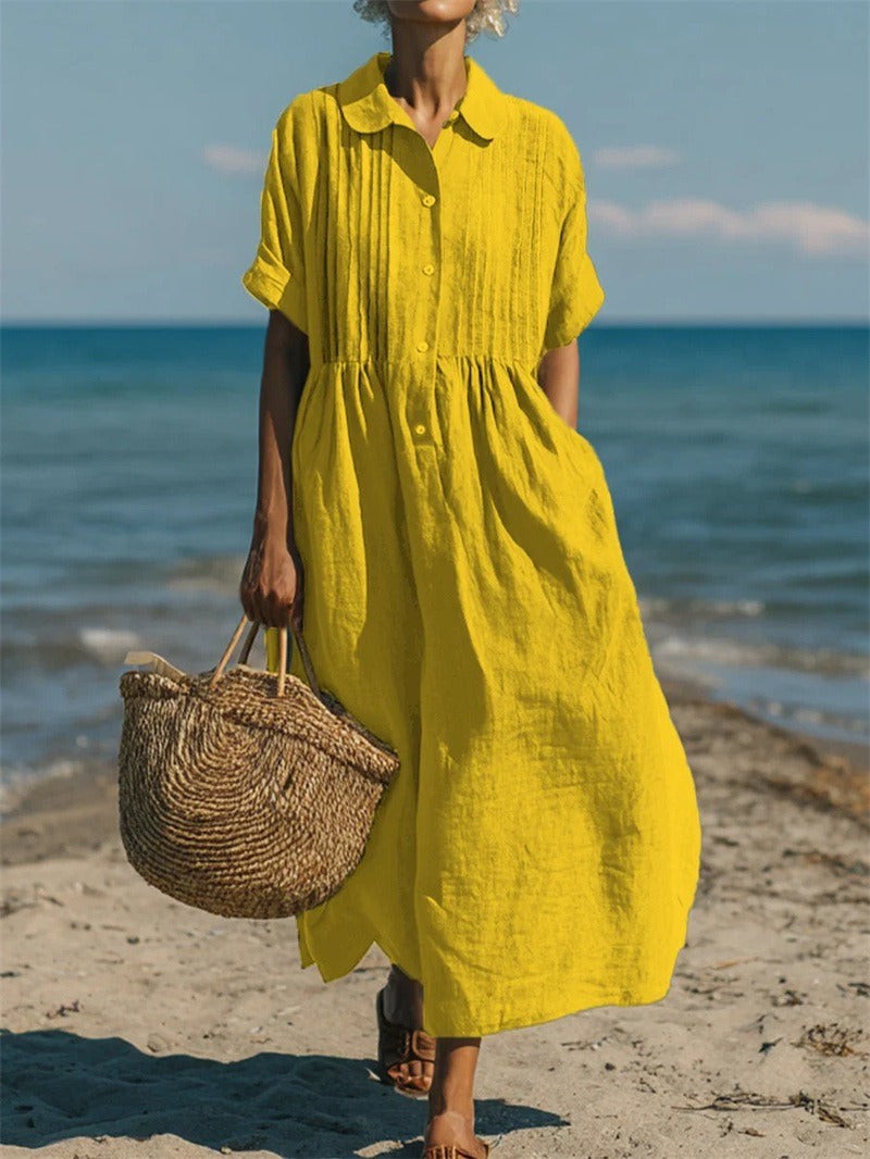 Bright yellow linen-look midi dress with button front on the beach