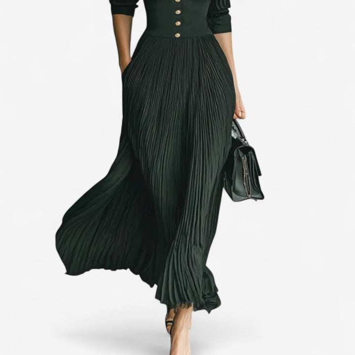 Close-up of pleated skirt detail on black button-front maxi dress