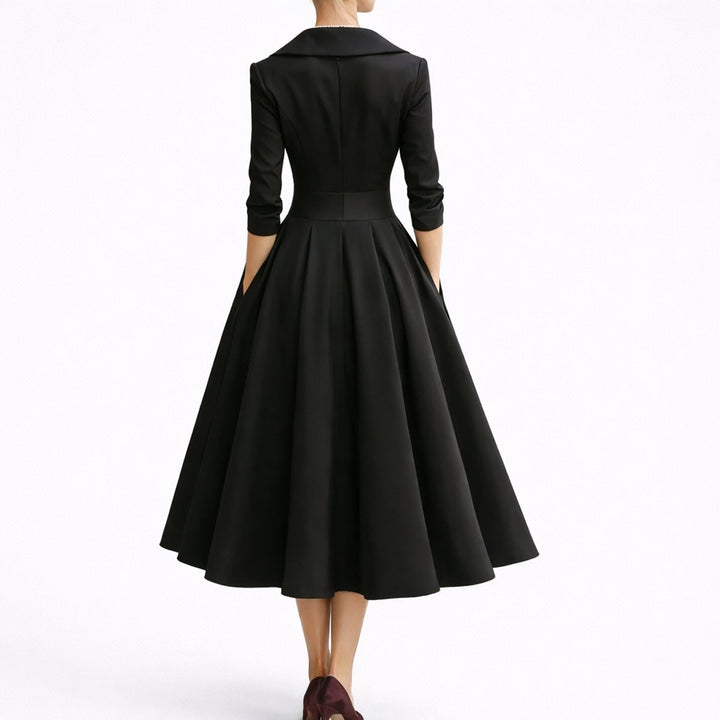 Rear view of black A-line midi dress showing tailored waistband