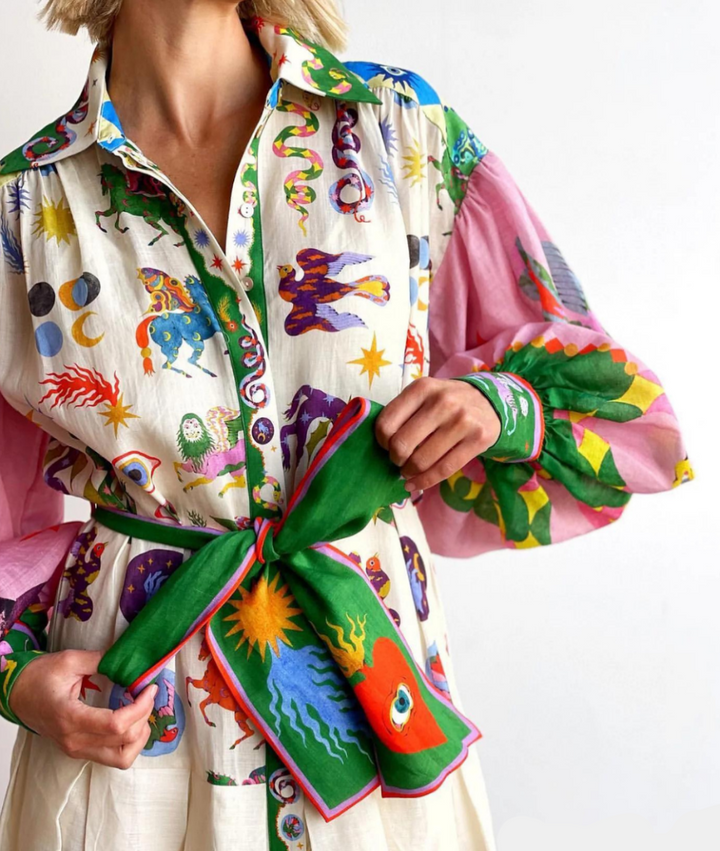Close-up of belted maxi dress showing star and eye motif print detail