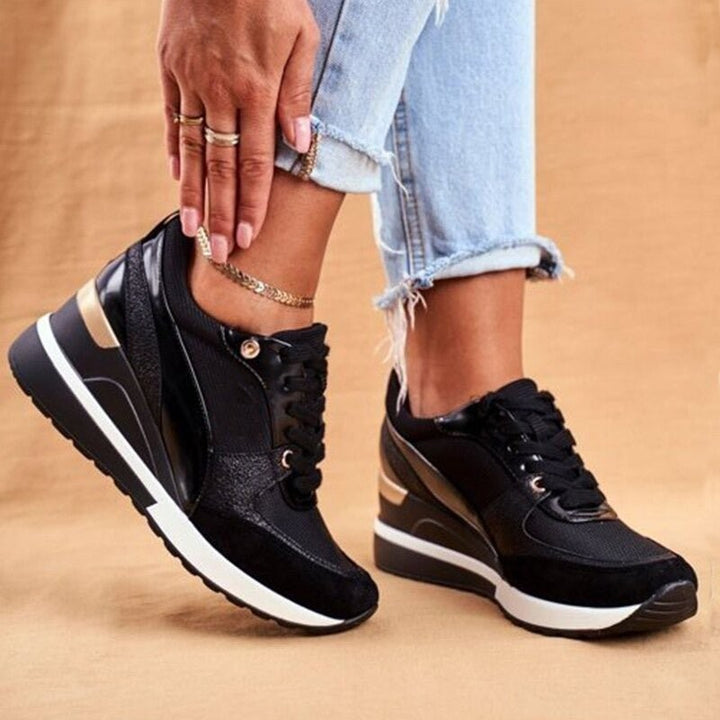 Black wedge trainers with glossy patent panels and lace-up front
