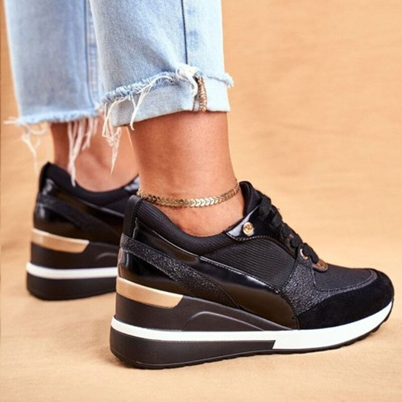 Black lace-up wedge sneakers with contrasting white sole and gold trim