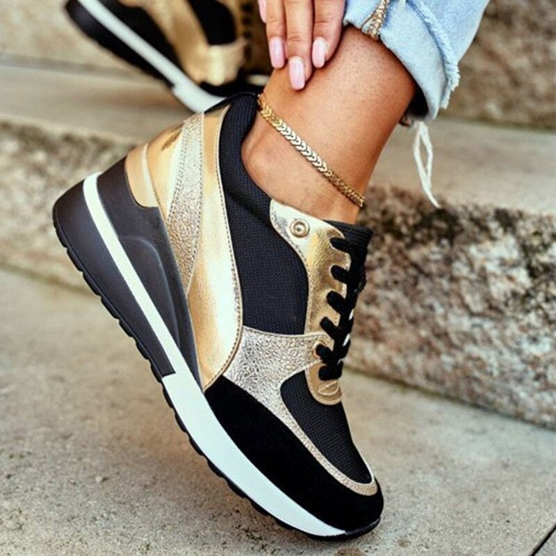 Gold and black platform trainers with lace-up fastening and chunky sole
