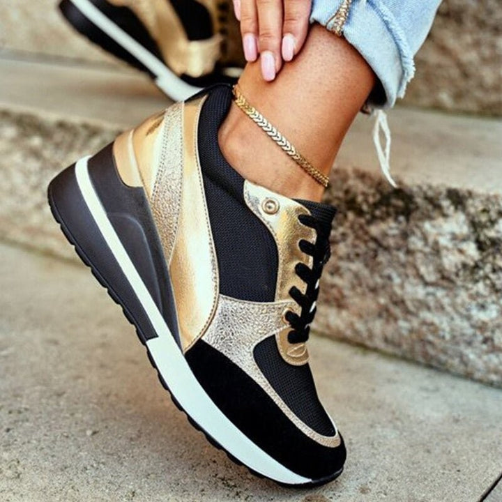 Gold and black platform trainers with lace-up fastening and chunky sole