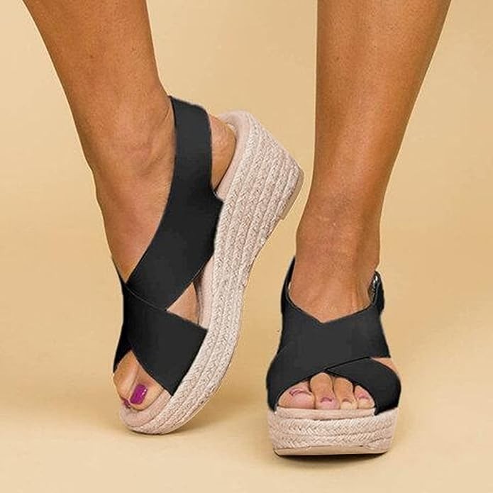 Black crossover strap espadrille wedge sandals worn on feet, close-up view