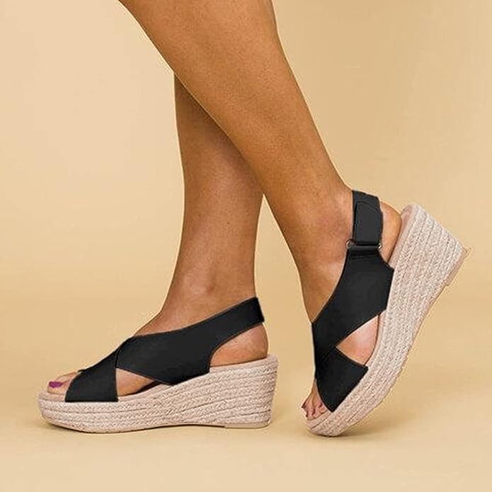 Black espadrille wedge sandals with crisscross straps, side profile on model