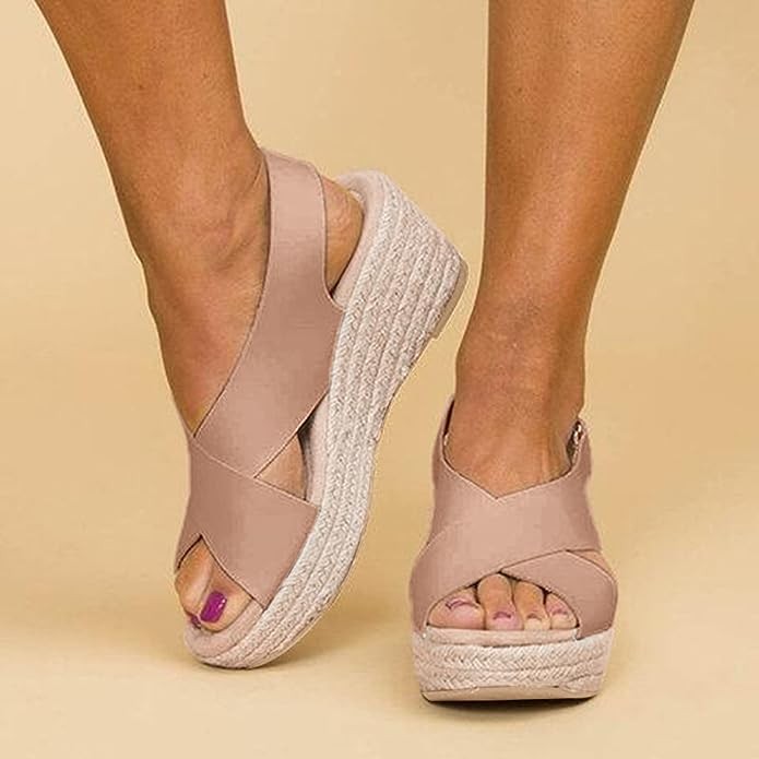 Nude crossover strap espadrille wedge sandals shown on model's feet