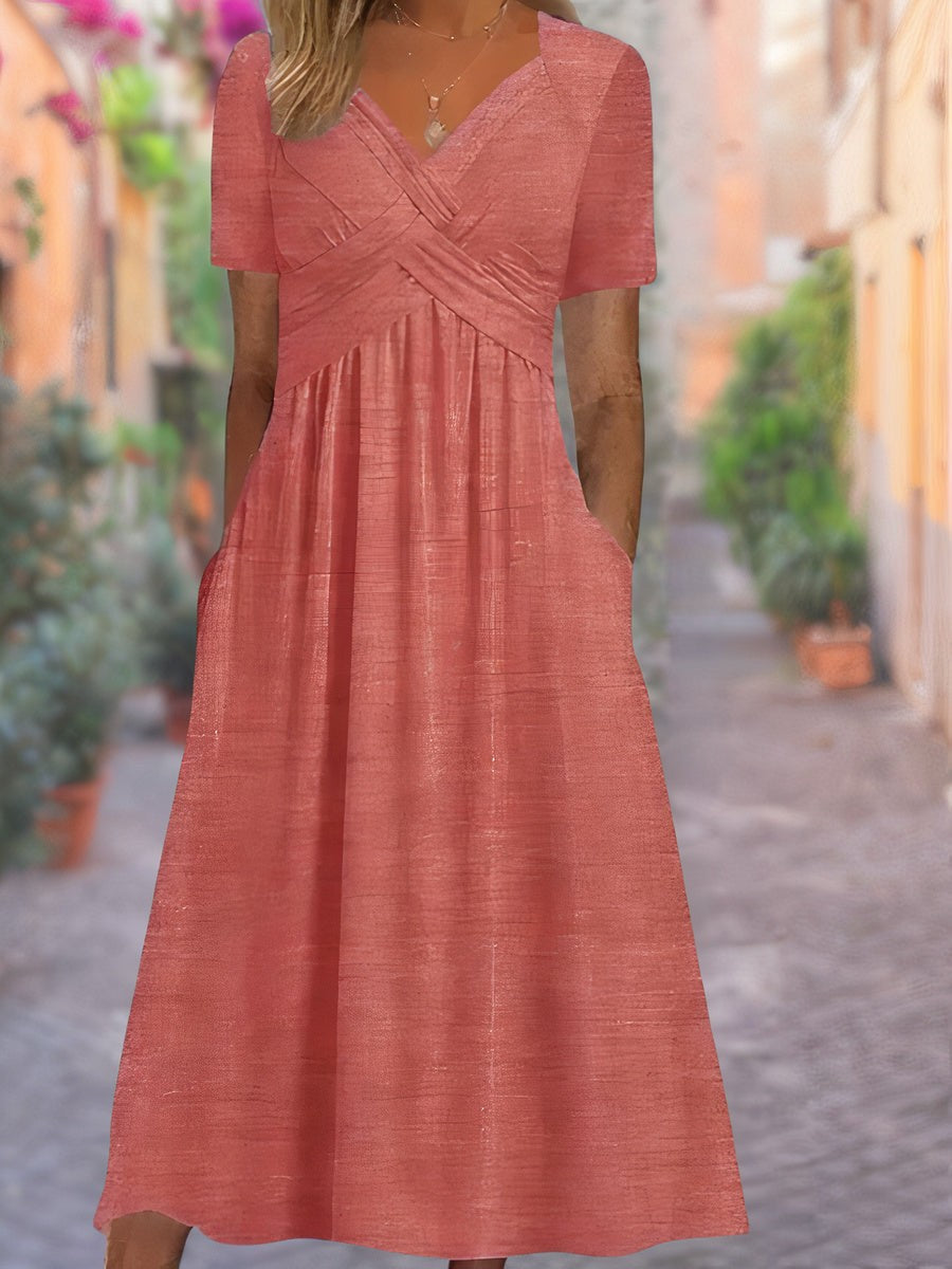 Coral midi dress showing textured fabric and crossover neckline