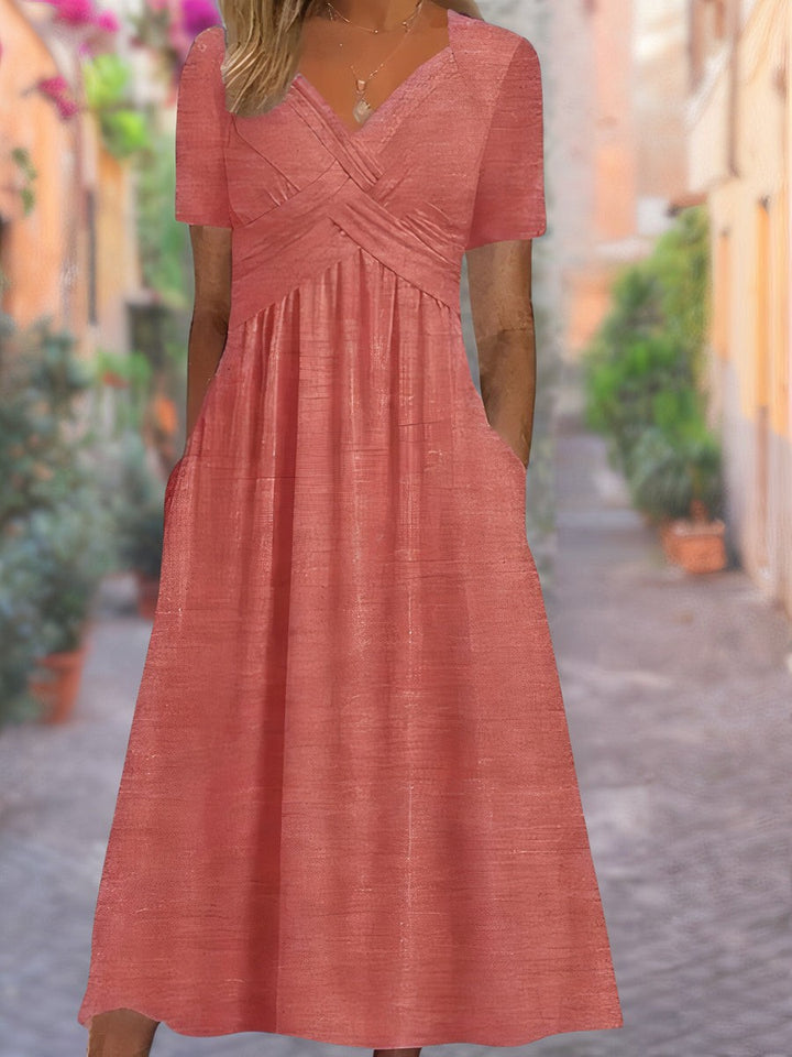 Coral midi dress showing textured fabric and crossover neckline