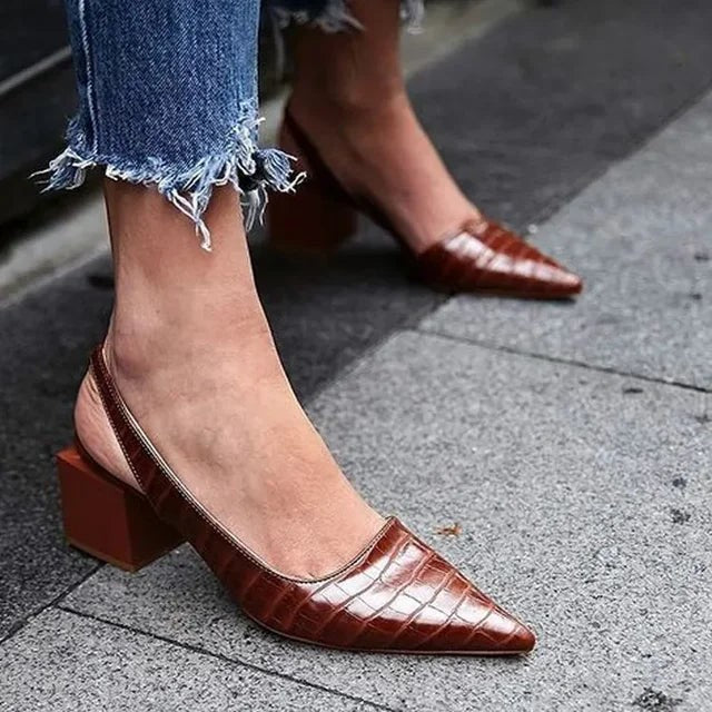 Tan croc-embossed slingback heels styled with distressed denim jeans
