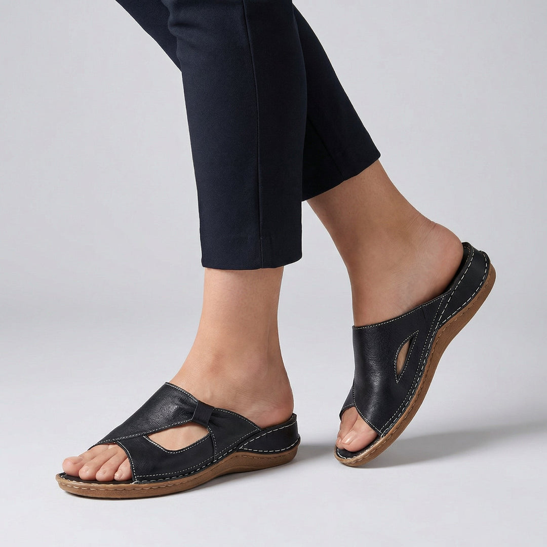 Black leather orthopedic slide sandal with contrast stitching and cut-out detail
