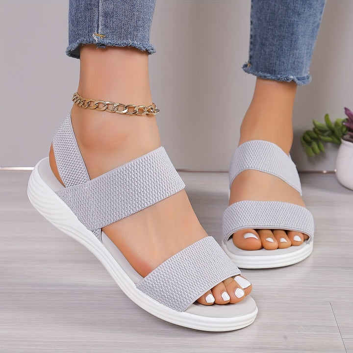 Blush pink open-toe sandals featuring ankle strap and white platform base