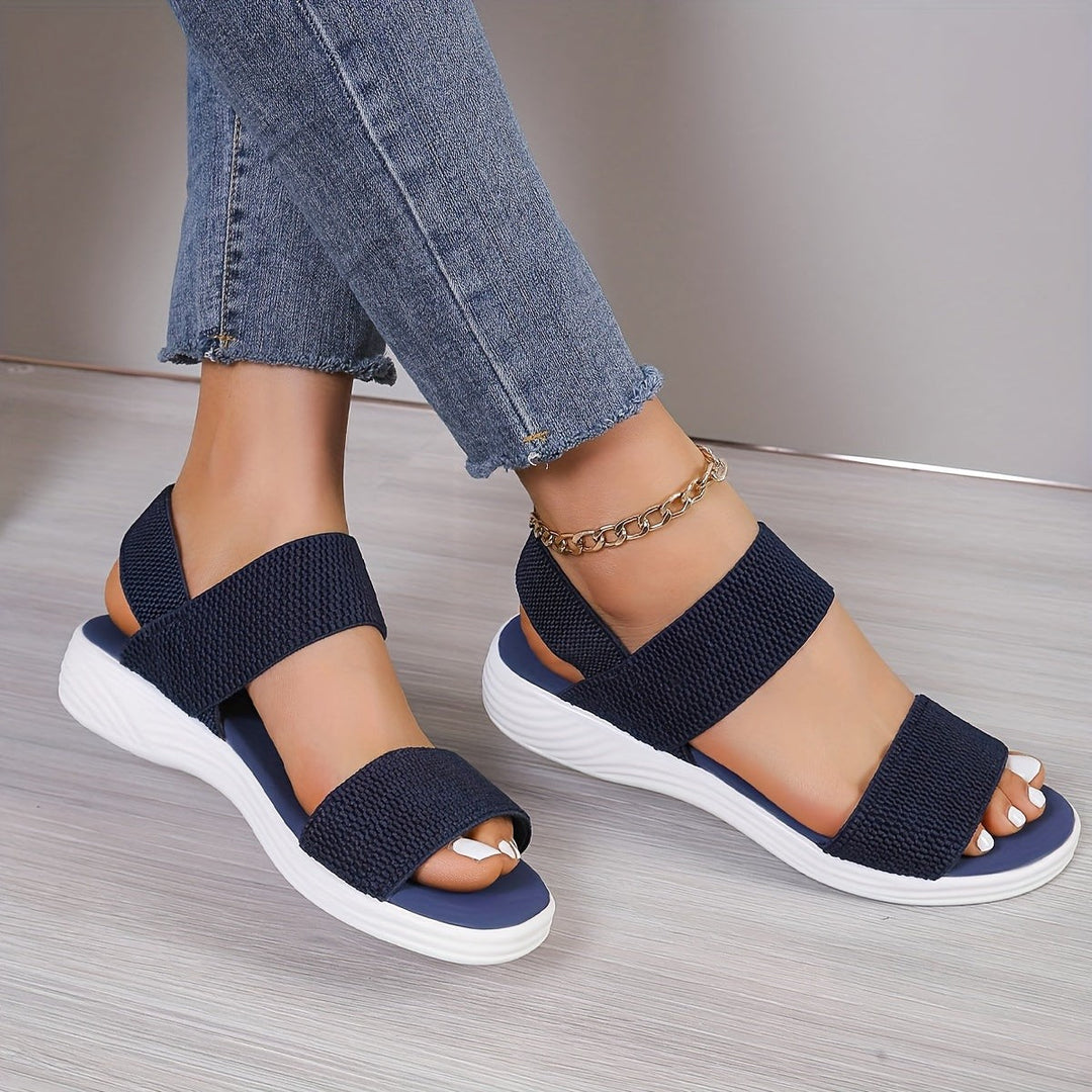 Navy criss-cross ankle strap sandals with ridged white wedge outsole