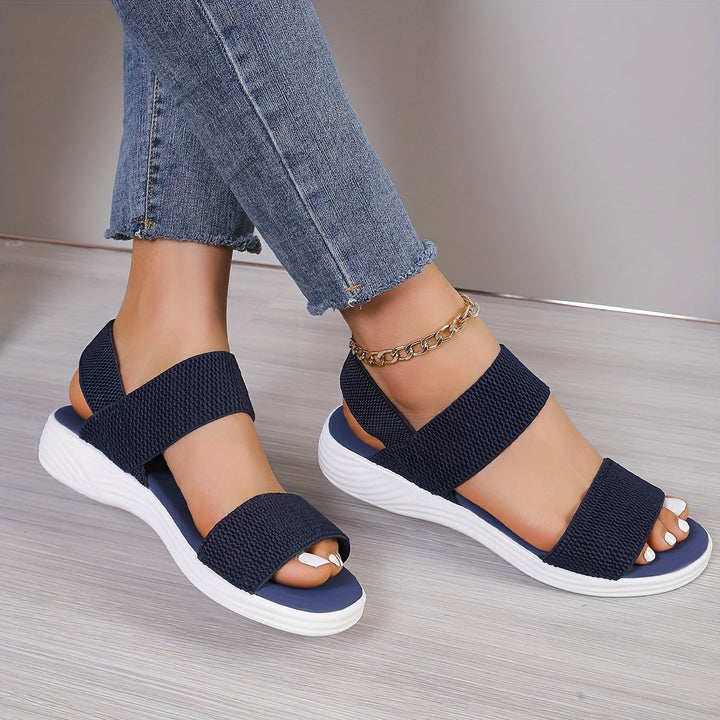 Navy criss-cross ankle strap sandals with ridged white wedge outsole