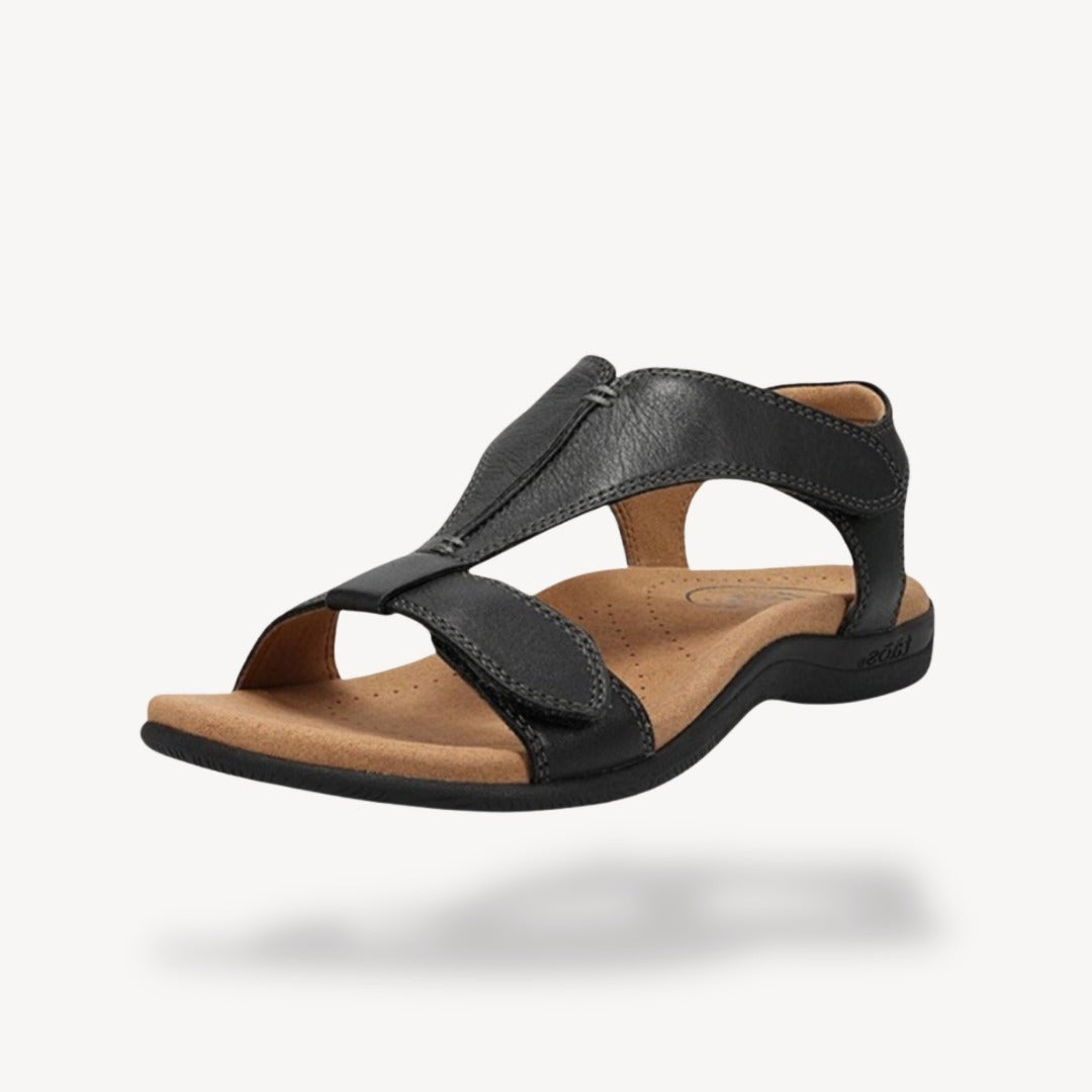 Black leather T-strap orthopedic sandal with cushioned tan footbed and touch-fasten straps