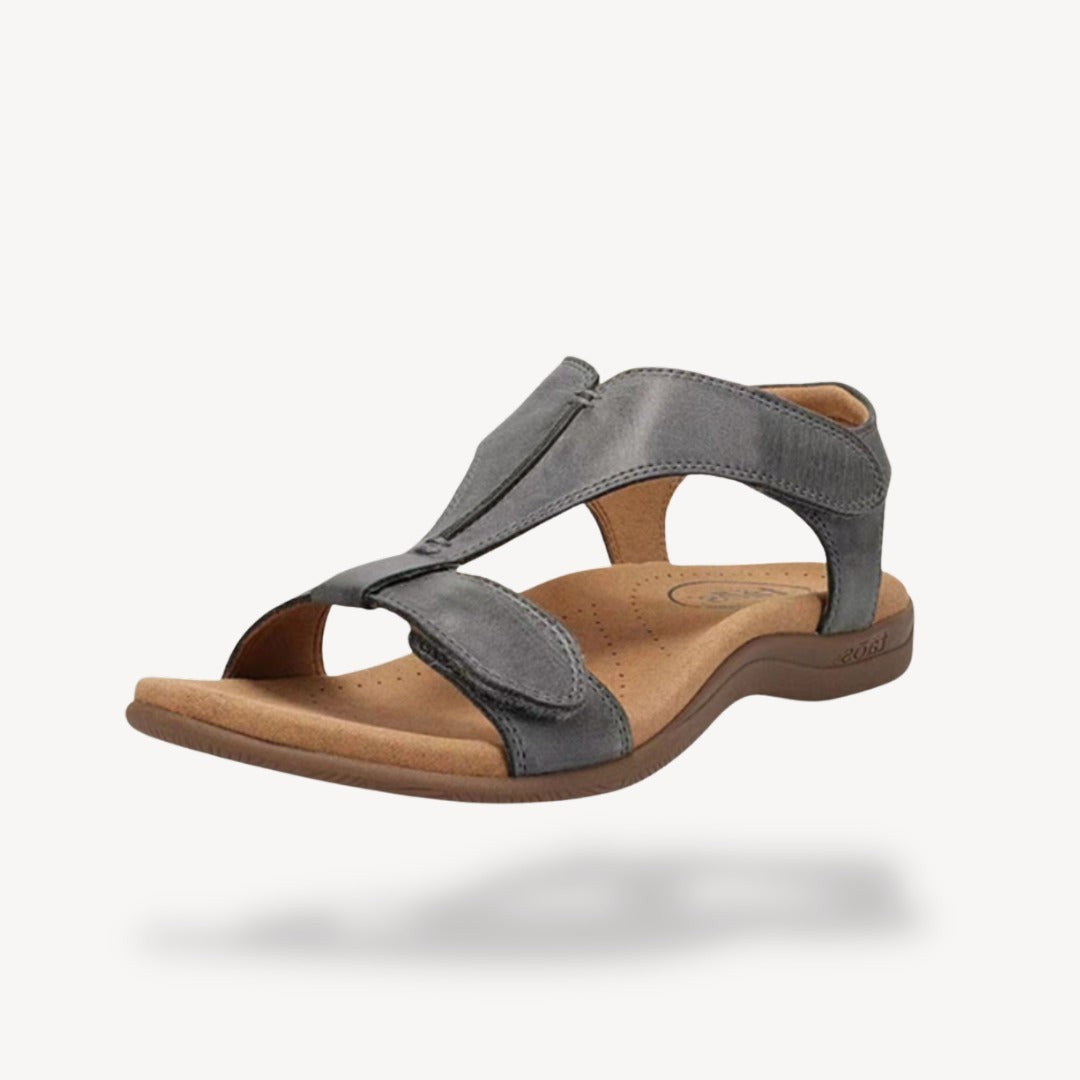 Grey leather T-strap orthopedic sandal featuring adjustable straps and contoured tan insole