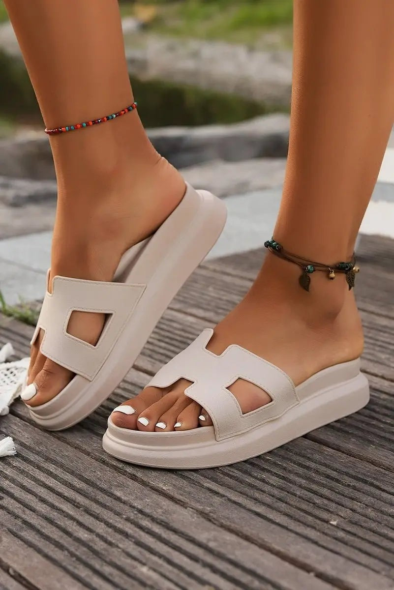 Close-up of beige platform slides with H-strap cut-out design on decking