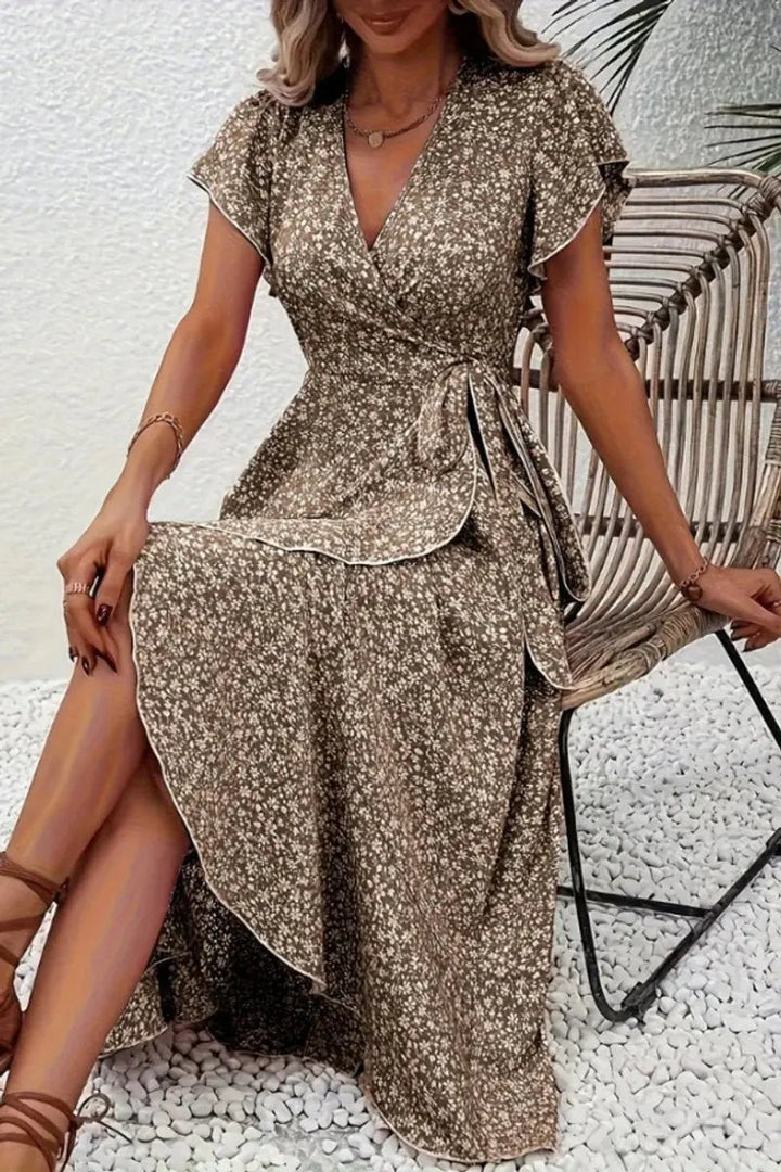 Brown floral wrap midi dress with ruffled sleeves and tie waist, seated pose
