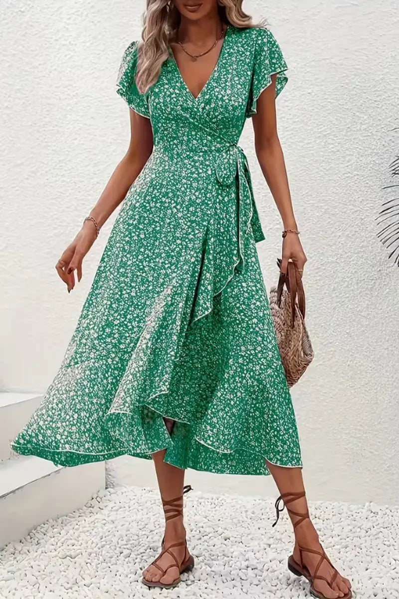 Green ditsy floral wrap dress worn with straw handbag and strappy sandals