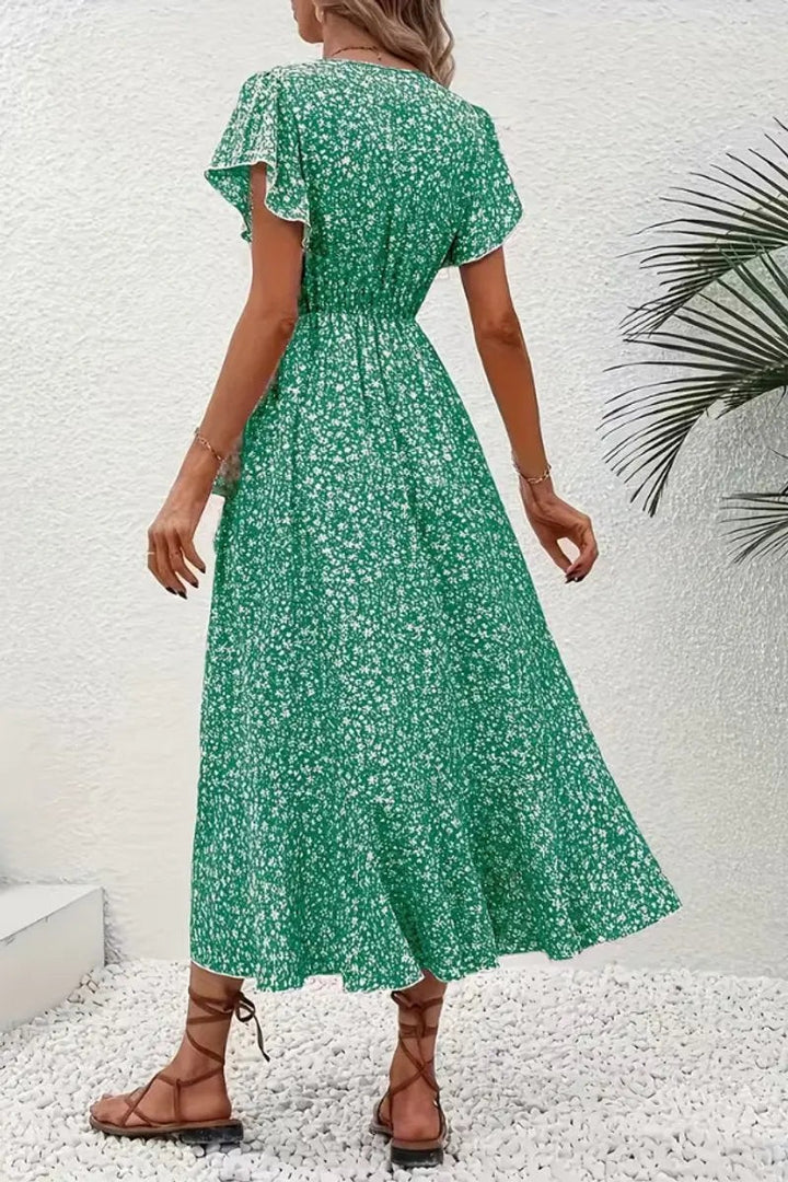 Back view of green floral wrap dress highlighting ruffled asymmetric hem