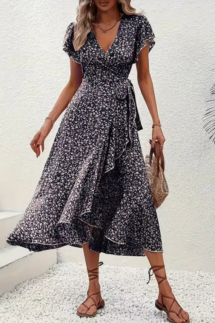 Black and white floral wrap dress styled with woven bag and sandals
