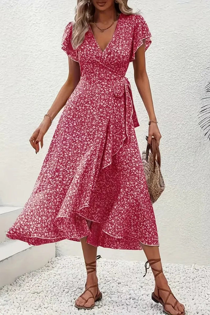 Red ditsy floral wrap dress paired with woven tote and tan sandals