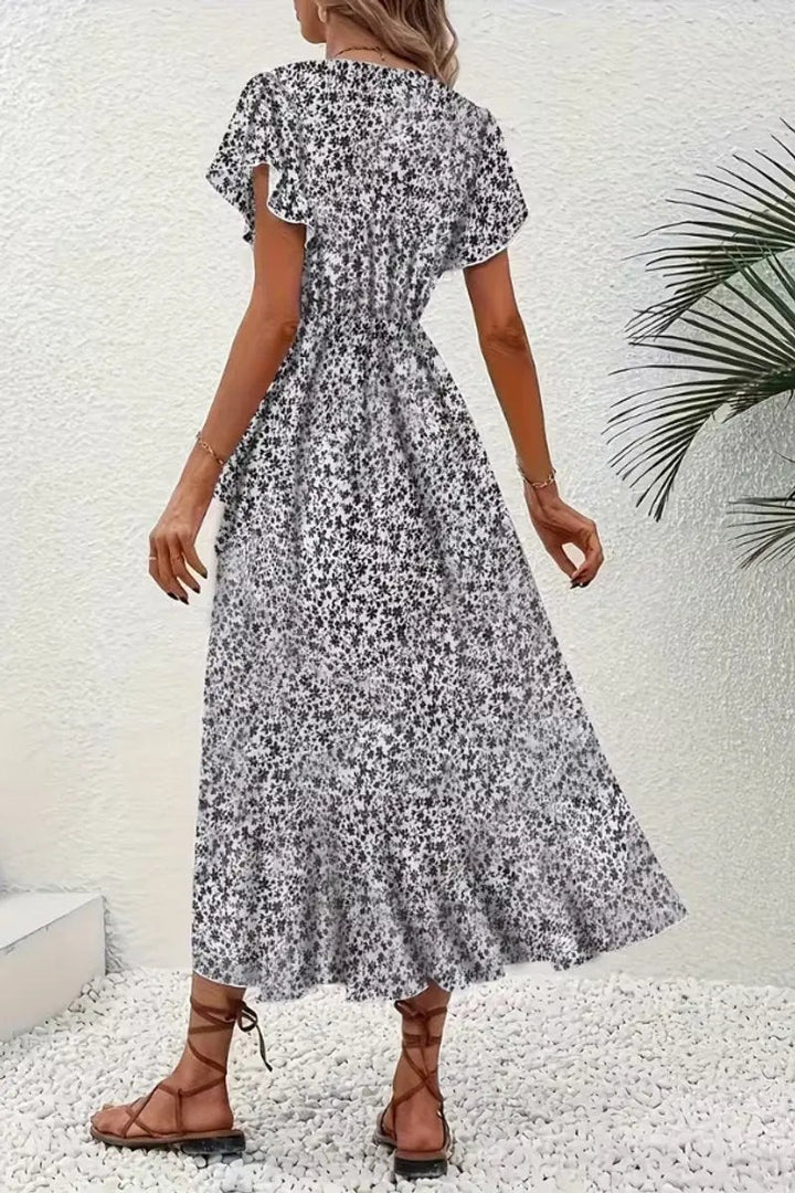 Back view of black and white floral wrap dress with cinched waist tie