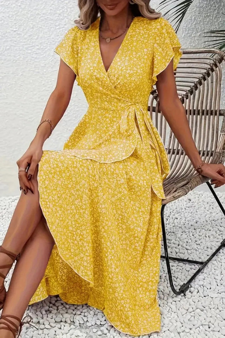 Mustard yellow floral wrap midi dress with ruffled cap sleeves, seated look