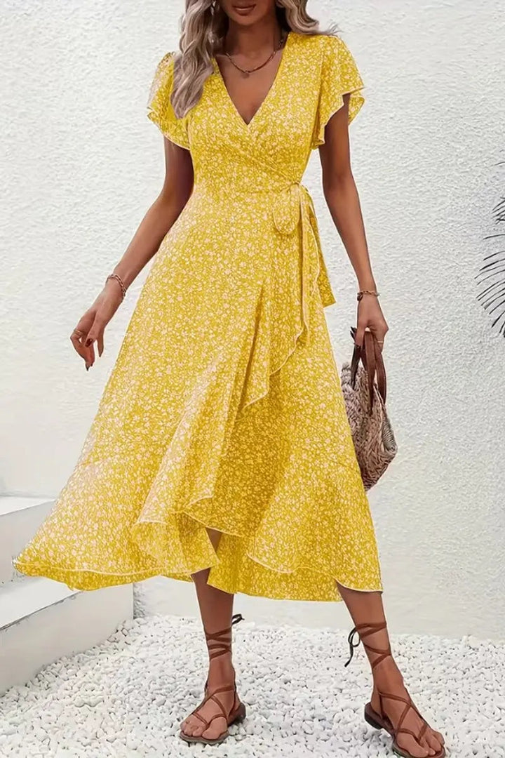 Yellow floral wrap dress with V-neckline styled with tan sandals and tote