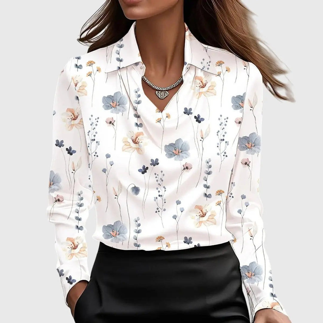 White satin blouse patterned with delicate blue and peach floral sprigs, long sleeves