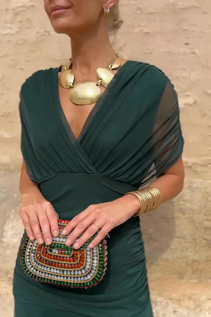 Close-up of draped V-neck bodice on dark green mesh maxi dress