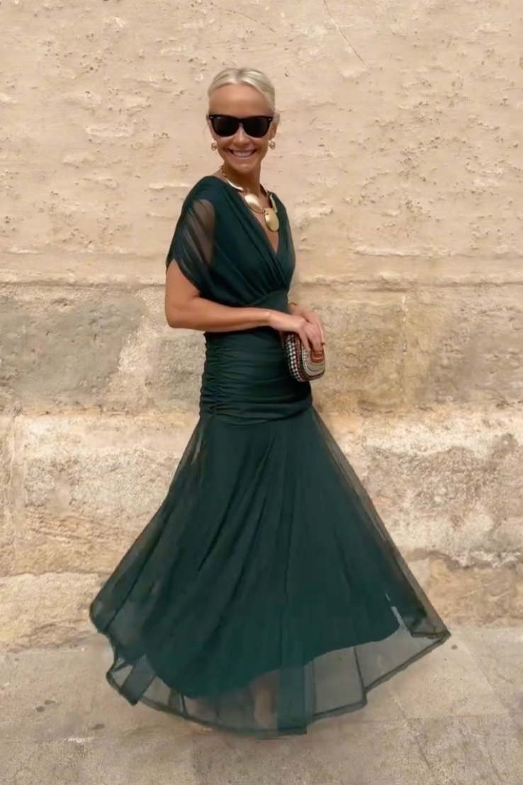 Side view of emerald maxi dress showing sheer tulle flared skirt