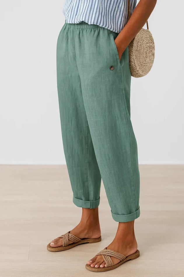 Sage green tapered trousers with rolled cuffs and side button pocket