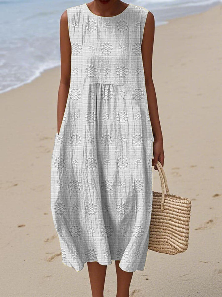 White sleeveless midi dress featuring subtle embroidered floral pattern