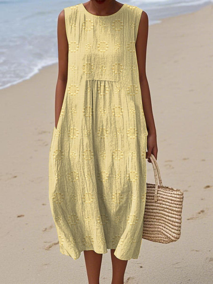 Pale yellow sleeveless midi dress with embroidered floral detailing and pockets