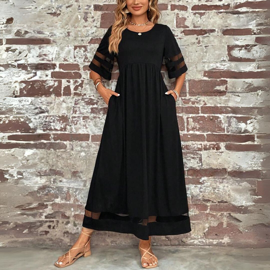 Black maxi dress with sheer mesh sleeve accents and pocketed skirt, front-facing view