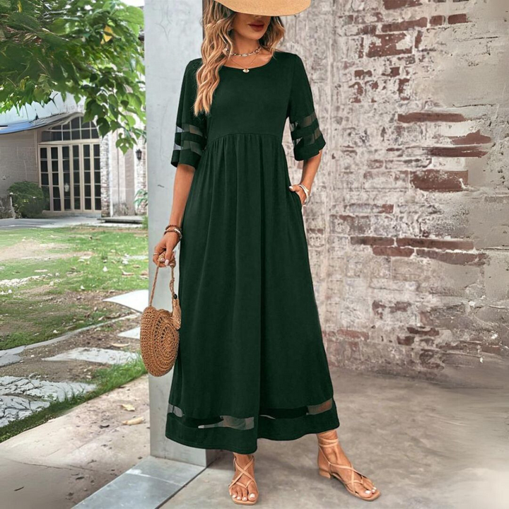 Green maxi dress with sheer mesh panels and relaxed A-line silhouette, worn outdoors