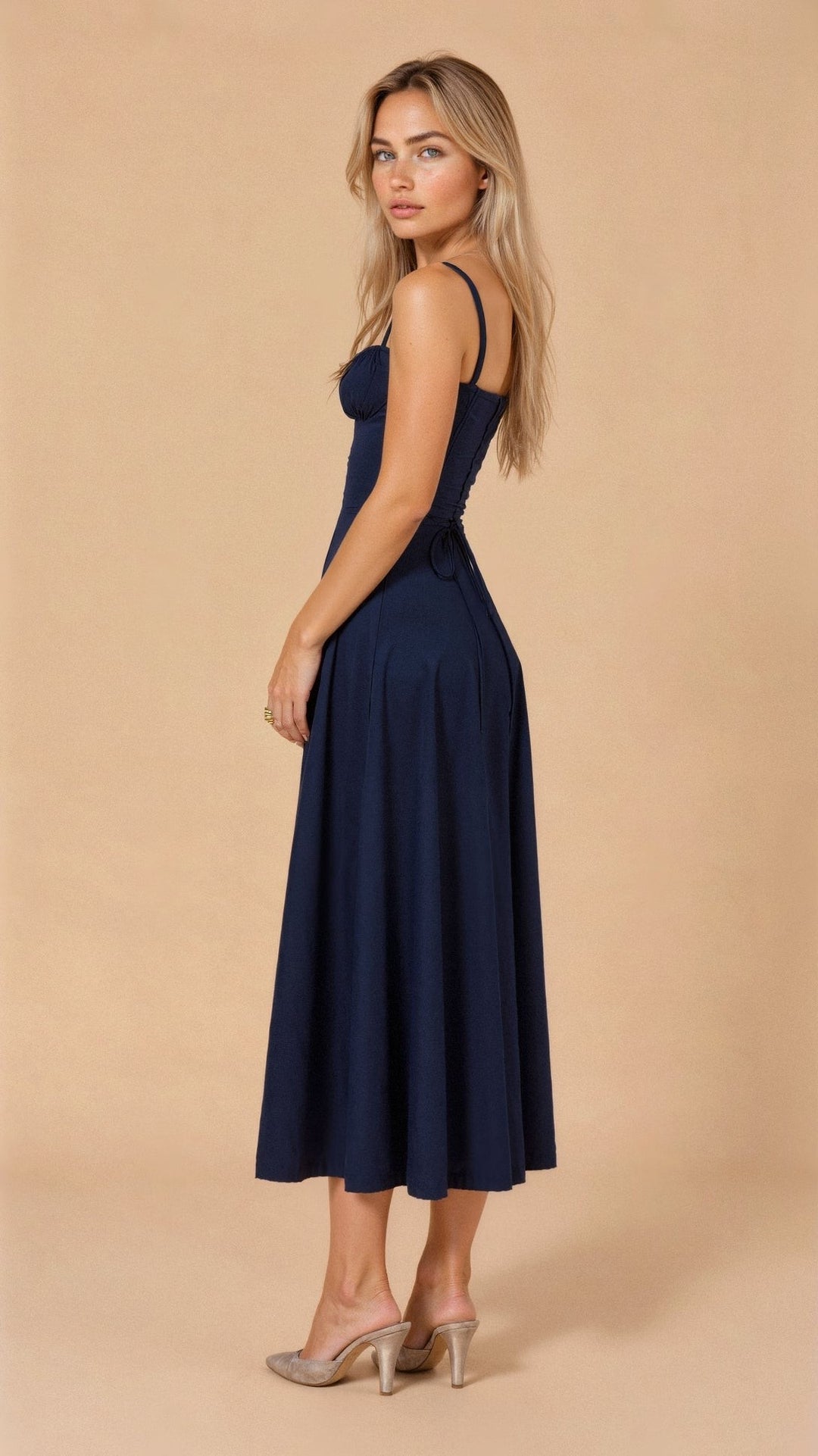 Rear view of navy corset midi dress showing ruched side-tie detail