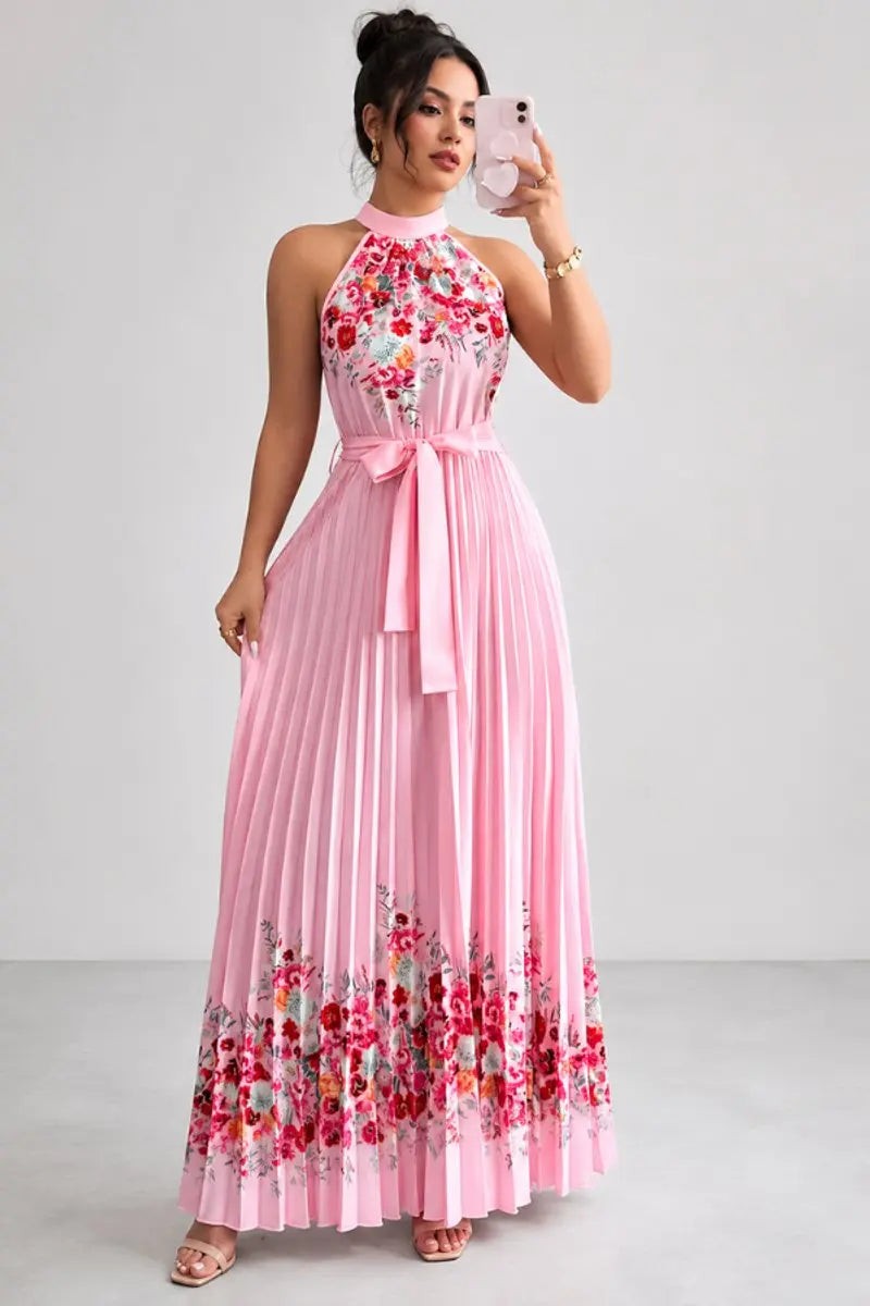 Model wearing pink floral pleated maxi dress with tie waist belt