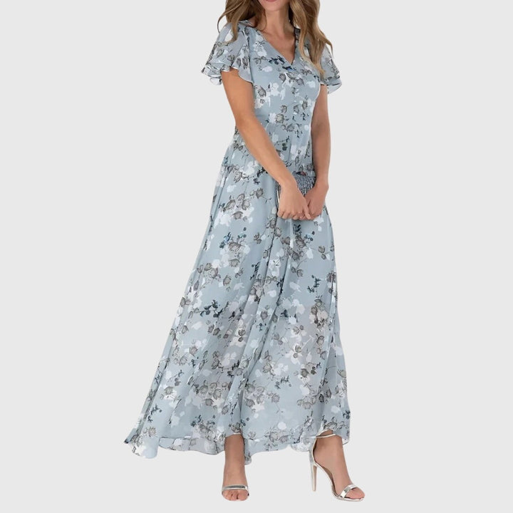 Dusty blue floral maxi dress featuring ruffled short sleeves and flowing skirt