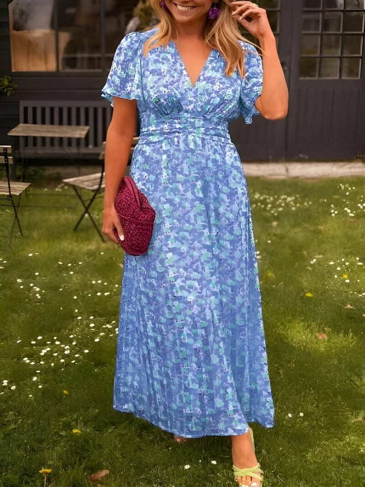 Blue floral maxi dress with flutter sleeves and cinched waist, close-up front view