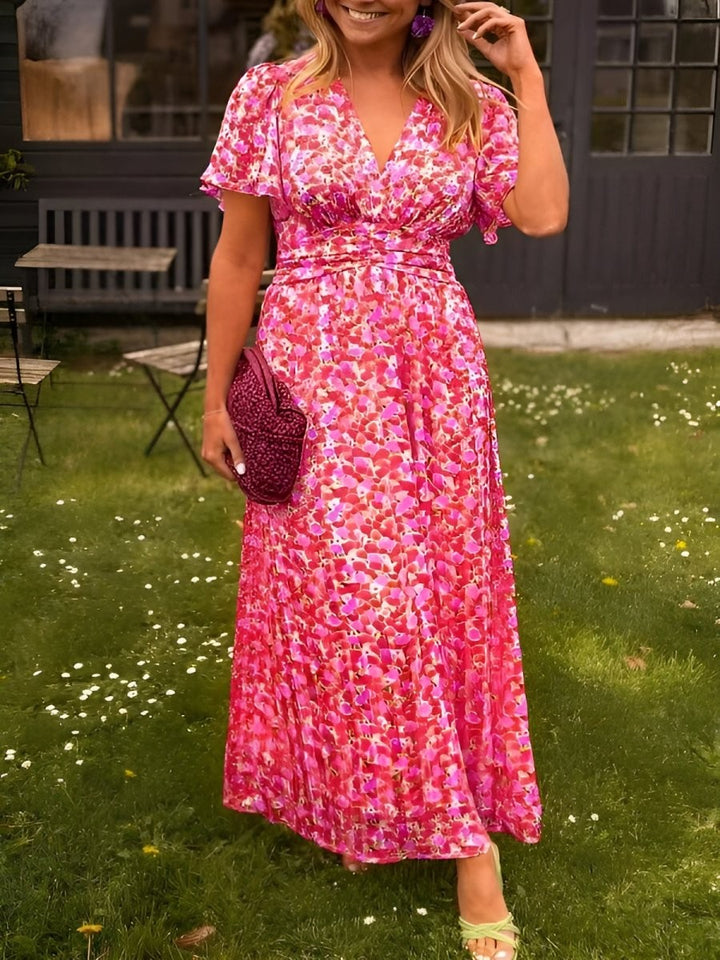 Pink floral maxi dress with V-neckline and flutter sleeves, close-up front view