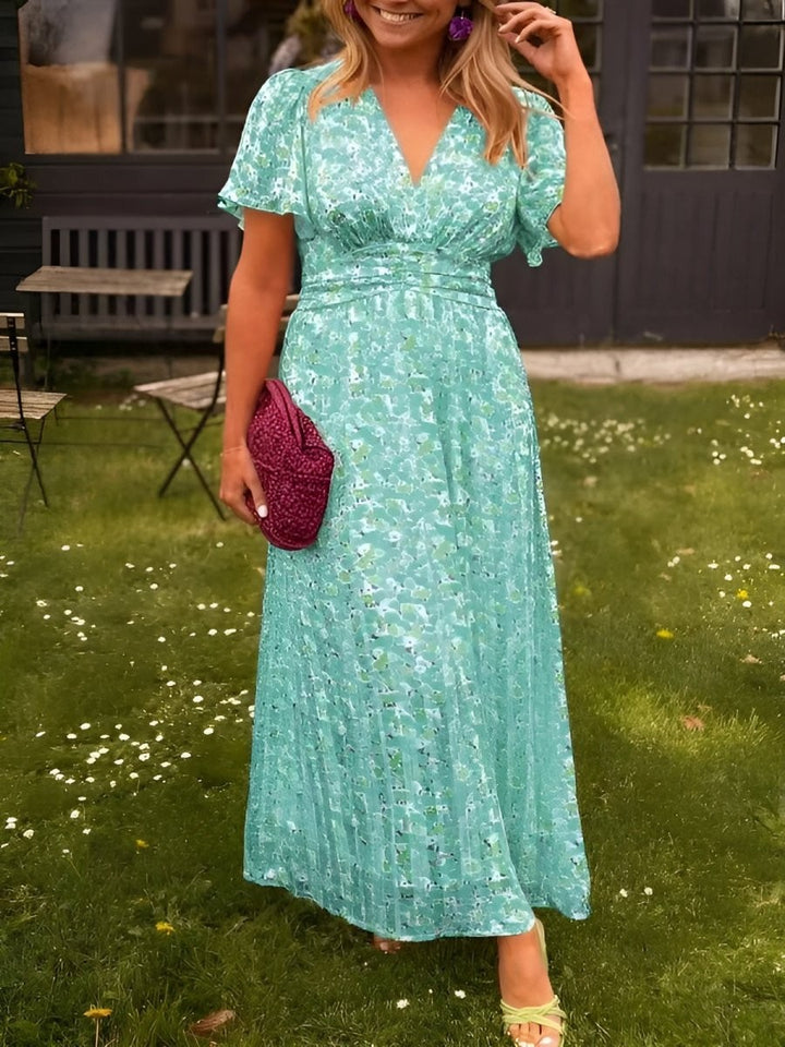 Mint green floral maxi dress with flutter sleeves and fitted waist, close-up view
