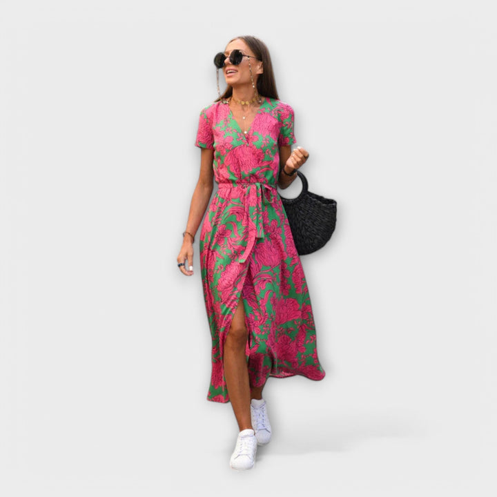 Front view of pink and green floral wrap dress paired with white trainers